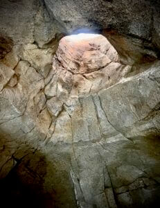 Looking up into the light in a reproduced cenote cave.